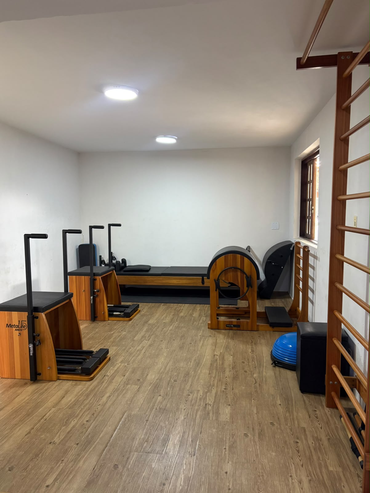 Sala de Pilates da SuzanFisio com equipamentos em madeira, barras e cadeira